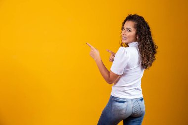 Neşeli afro kadın fotokopi çekmeyi işaret ediyor, muhteşem reklamları tartışıyor, yer ve yön veriyor. Sırtı yana dönük bir kadın