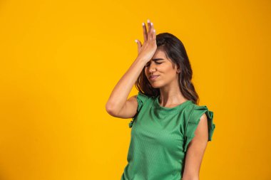 Güzel kadın unutulmuş ve sarı arka planda kafası karışmış.