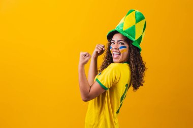 Brezilyalı destekçi. Brezilyalı kadın taraftarlar futbol ya da futbol maçını sarı arka planda kutluyorlar. Brezilya renkleri. Evet!!