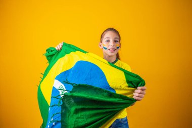 Sarı arka planda Brezilya bayrağı olan küçük beyaz bir kız. Brezilyalı çocuk destekçisi