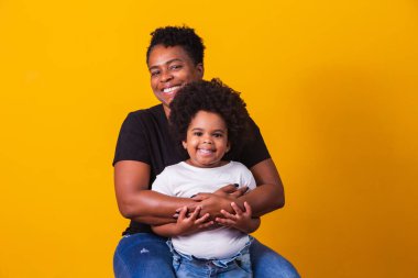 Anneler Günün kutlu olsun! Şirin küçük kızı olan sevimli Afro-Amerikan annesi. Yaşlı anne ve kızı sarı arka planda..