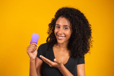 Genç kadın eli mor kart modelini tutuyor. Elinde alışveriş kartı tutan kadın. Elinde kredi kartı tutan güzel genç bir kadın.