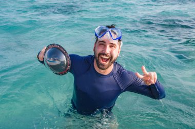 Denizde yüzme gözlüklü genç bir çocuğun resmi. Tatildeki adam okyanusun tadını çıkarıyor.