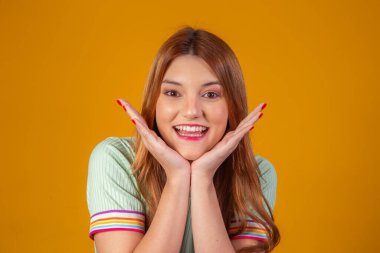 Genç kızıl, kameraya bakıp gülümsüyor.