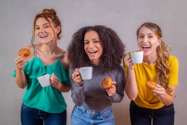 Arkadaşlar çay içip, çörek yiyip, sütlü kahve içiyorlar.