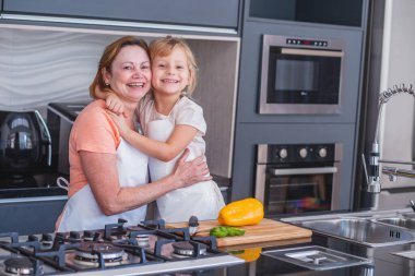 Anneler Günün kutlu olsun! Çocuk kız ve anne evde yemek pişiriyor ve eğleniyorlar. Aile tatili ve birliktelik.