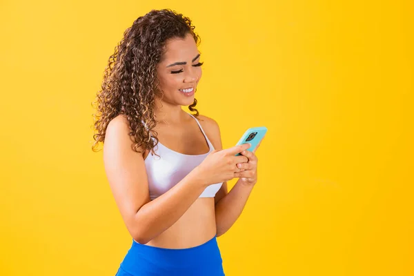 Influenciador Mujer Traje Fitness Utilizando Teléfono Celular Sobre Fondo Amarillo —  Fotos de Stock