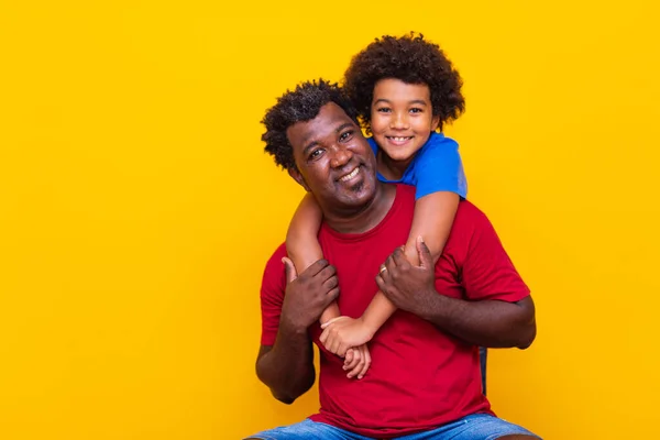 黄色の背景に父と息子 子供の日または父の日の概念 — ストック写真