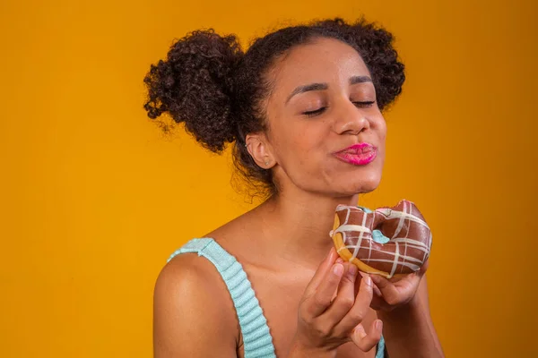 年轻的非洲女人吃美味的巧克力甜甜圈 — 图库照片
