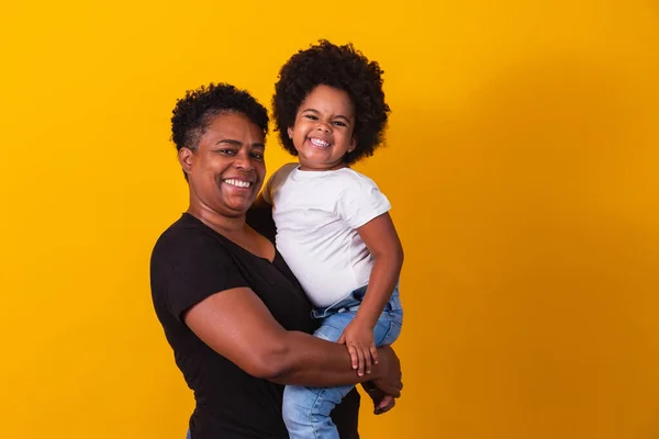 幸せなお母さんの日 可愛い小さな娘を持つ愛らしい甘いアフロアメリカの母親 年上の母とともに彼女の娘上の黄色の背景 — ストック写真
