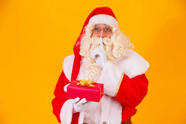 Santa Claus Žlutém Pozadí Drží Dar Rukou Druhou Rukou Dělá — Stock fotografie