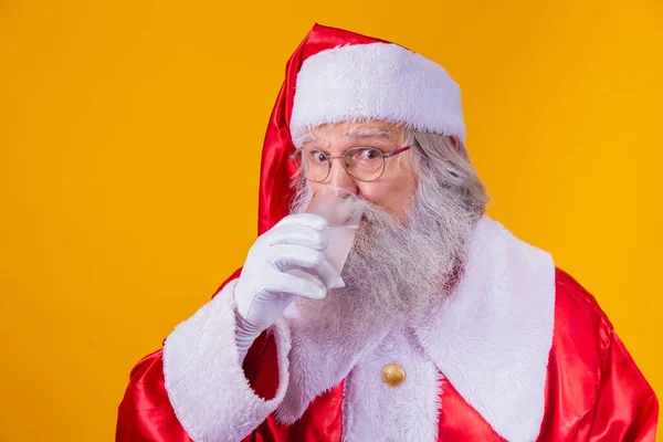 stock image Santa Claus drinking a glass of water on yellow background with space for text. Health and hydration concept