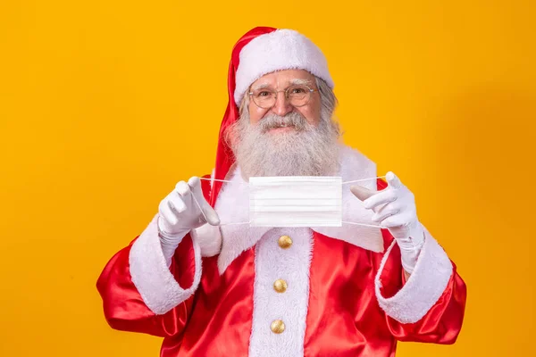 Real Santa Claus Yellow Background Holding Protective Mask Glasses Hat — Stock Photo, Image