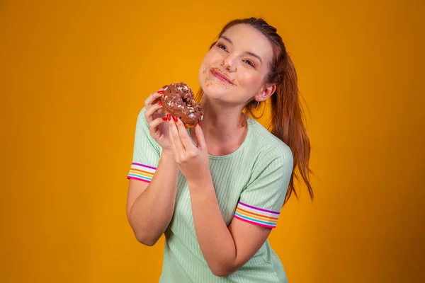 Молодая Рыжая Женщина Ест Вкусные Шоколадные Пончики Мазью Рту — стоковое фото