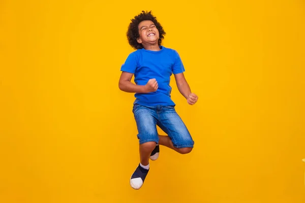 Sarı Arka Planda Zıplayan Küçük Afro Çocuk — Stok fotoğraf