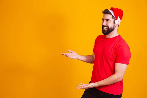 Knappe Man Gekleed Voor Kerstmis Met Kerstman Hoed Wijzend Naar — Stockfoto