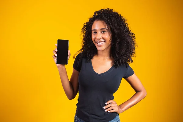 Sarı Arka Planda Boş Cep Telefonu Tutan Afro Saçlı Mutlu — Stok fotoğraf