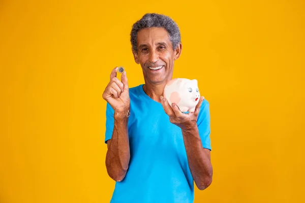 Uomo Anziano Che Tiene Salvadanaio Una Moneta Brasiliana Sfondo Giallo — Foto Stock