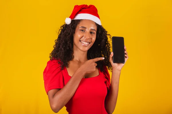 Uśmiechnięta Młoda Mikołajowa Kobieta Świątecznym Kapeluszu Trzyma Telefon Komórkowy Pustym — Zdjęcie stockowe
