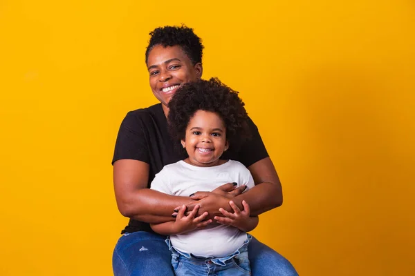 幸せなお母さんの日 可愛い小さな娘を持つ愛らしい甘いアフロアメリカの母親 年上の母とともに彼女の娘上の黄色の背景 — ストック写真