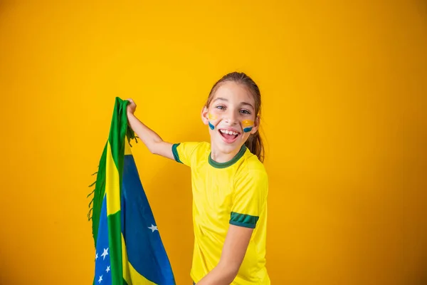 黄色の背景にブラジルの旗を持つ小さな白人の女の子 ブラジルの児童支援者 — ストック写真