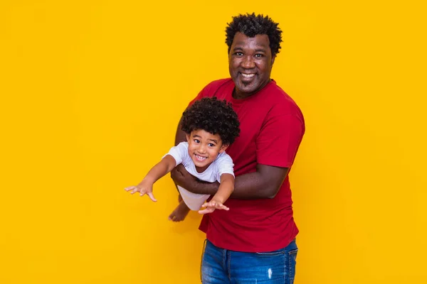 黄色の背景に父とアフロの息子の笑顔と演奏 父の日のコンセプト — ストック写真