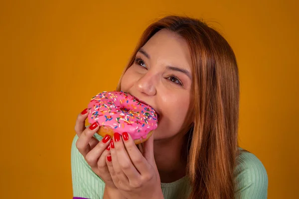 吃黄色背景粉红甜甜圈的女孩 — 图库照片