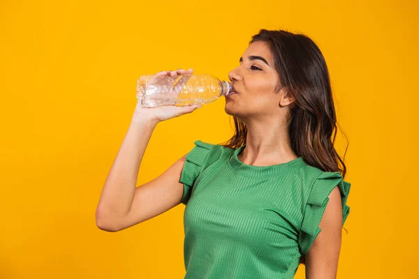 Mujer Joven Bebiendo Agua Una Pequeña Botella Sobre Fondo Amarillo — Foto de Stock