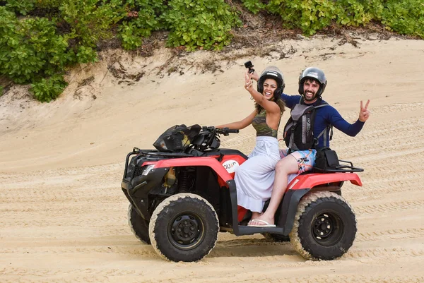 stock image Natal, Rio Grande do Norte, Brazil - March 12 2021: Couple riding a quad on the maracajau promenade in rio grande do norte