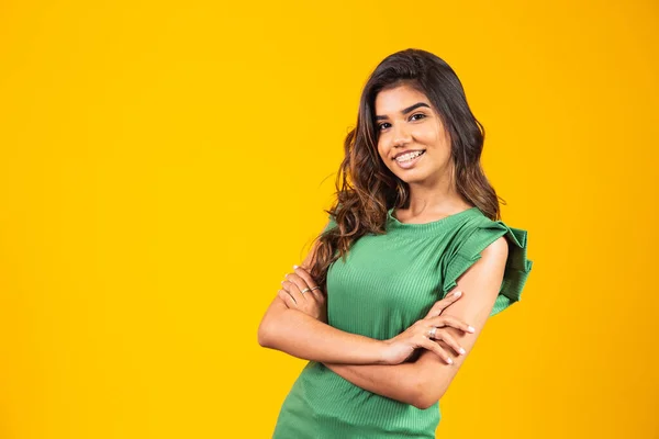 Sarı Arka Planda Kollarını Kavuşturmuş Gülümseyen Genç Bir Kız — Stok fotoğraf