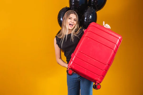 Funny woman holding a heavy travel bag.Travel promotion anniversary. Black Friday on travel tickets.
