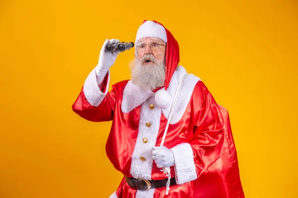 Studio Shot Van Kerstman Zoek Door Een Verrekijker Geïsoleerd Gele — Stockfoto