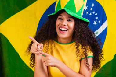 Siyah kadın hayranı. Arka planda Brezilya renkleri, yeşil, mavi ve sarı. Seçimler, futbol veya siyaset.