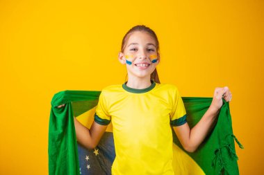 Futbol taraftarı, Brezilya takımı. Güzel küçük kız sarı arka planda takımı için tezahürat yapıyor.