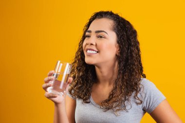 Güzel genç bayan bir bardak su içiyor.