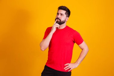 Heyecanlı adam sarı arka planda izole edilmiş büyük bir fikre işaret ediyor..