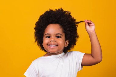 Siyah saçlı, kameraya gülümseyen tatlı afro kız. Kara gün. Çocuk Günü