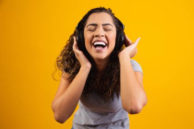 Kulaklıklarıyla müzik dinleyen afro genç kız.