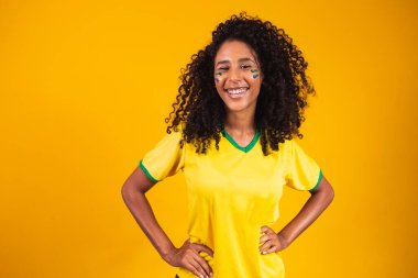 Brezilyalı destekçi. Brezilyalı kadın taraftarlar futbol ya da futbol maçını sarı arka planda kutluyorlar. Brezilya renkleri.