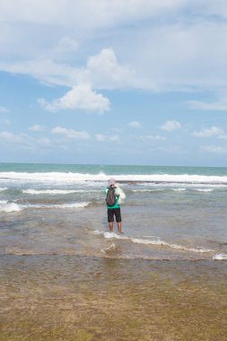 Denizde oltayla balık tutan bir adam.