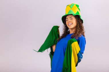 Brezilyalı bir hayran. Portrede Brezilya bayrağı takan Brezilyalı bir taraftar futbolu ya da futbol maçını arka planda kutluyor. Dünya Kupası