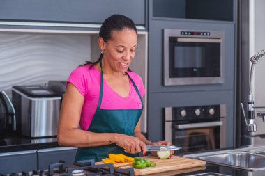 Kadın bıçak kullanıyor ve soğan doğruyor..