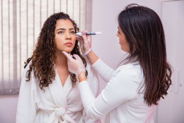 Yüz estetiği konsepti. Estetik prosedüre başlamak için yüz işaretleme yapıyorum. Güzellik kliniğindeki kadın