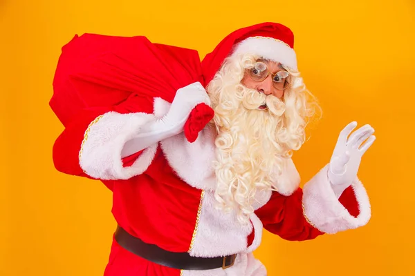 Święty Mikołaj Żółtym Tle Trzyma Torbę Prezentami Plecami Święty Mikołaj — Zdjęcie stockowe