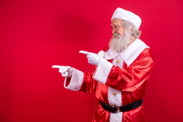 Weihnachtsmann Zeigt Beiseite Weihnachtswerbung Silvester Rabattwerbung Isoliert Auf Rotem Hintergrund — Stockfoto