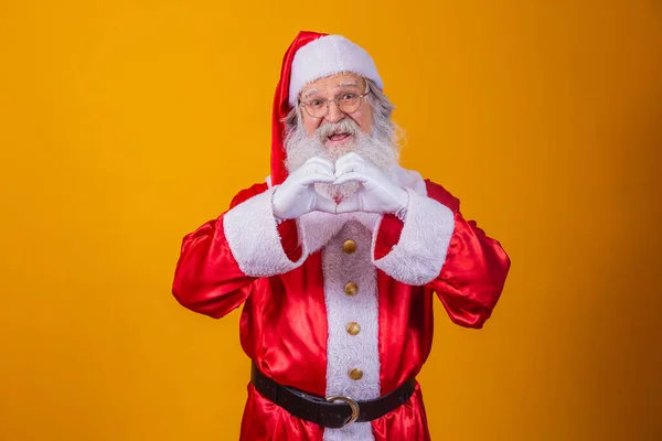 Санта Клаус Делает Знак Сердца Своими Руками Желтом Фоне — стоковое фото