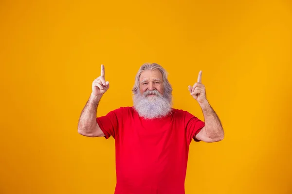 stock image old man with long beard with fingers pointing up in free space for text.