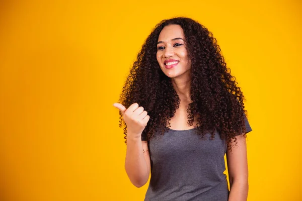 美丽的非洲裔美国女人 卷曲的头发 用她的手做着一个快乐的竖起大拇指的手势 看着成功镜头的认可表情 — 图库照片