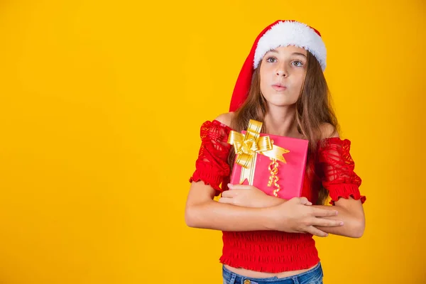 Roztomilý Veselý Dívka Vánoční Klobouk Barevném Pozadí Drží Dárek — Stock fotografie