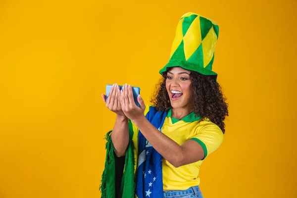 スマートフォンを見て目標を祝うブラジルのサッカーチームのサポーター — ストック写真